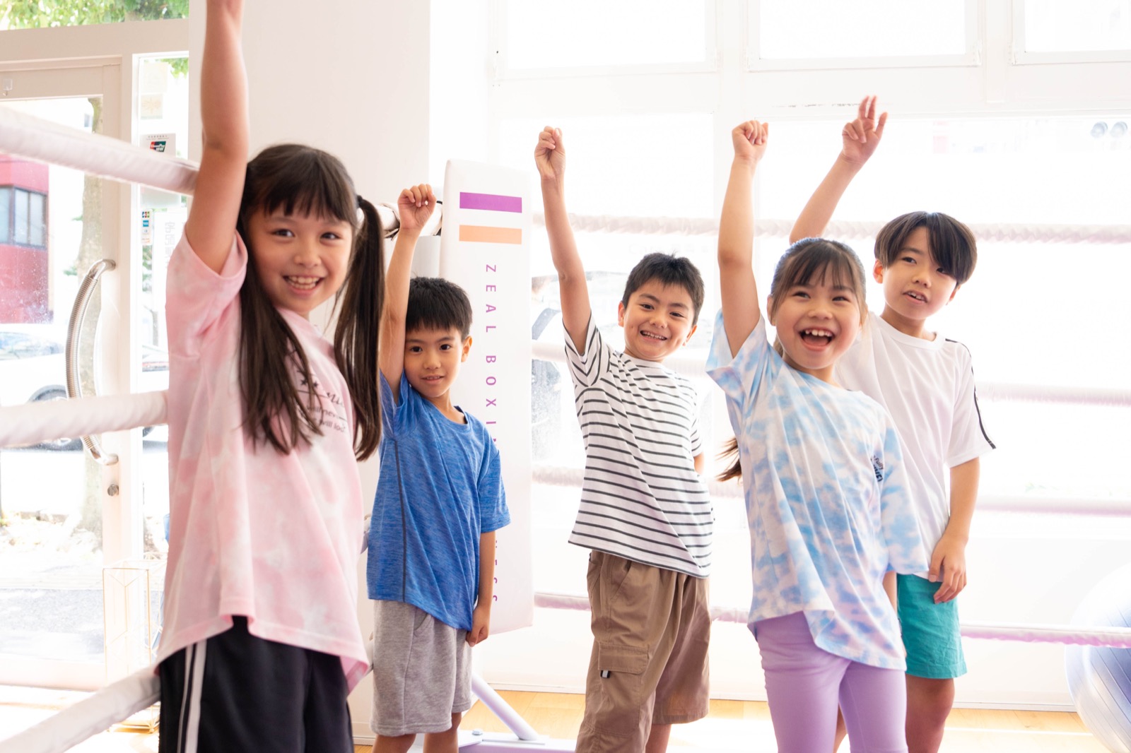 English Fight Kidsのジムで、コーチと一緒に明るくボールトレーニングを行う子どもたち